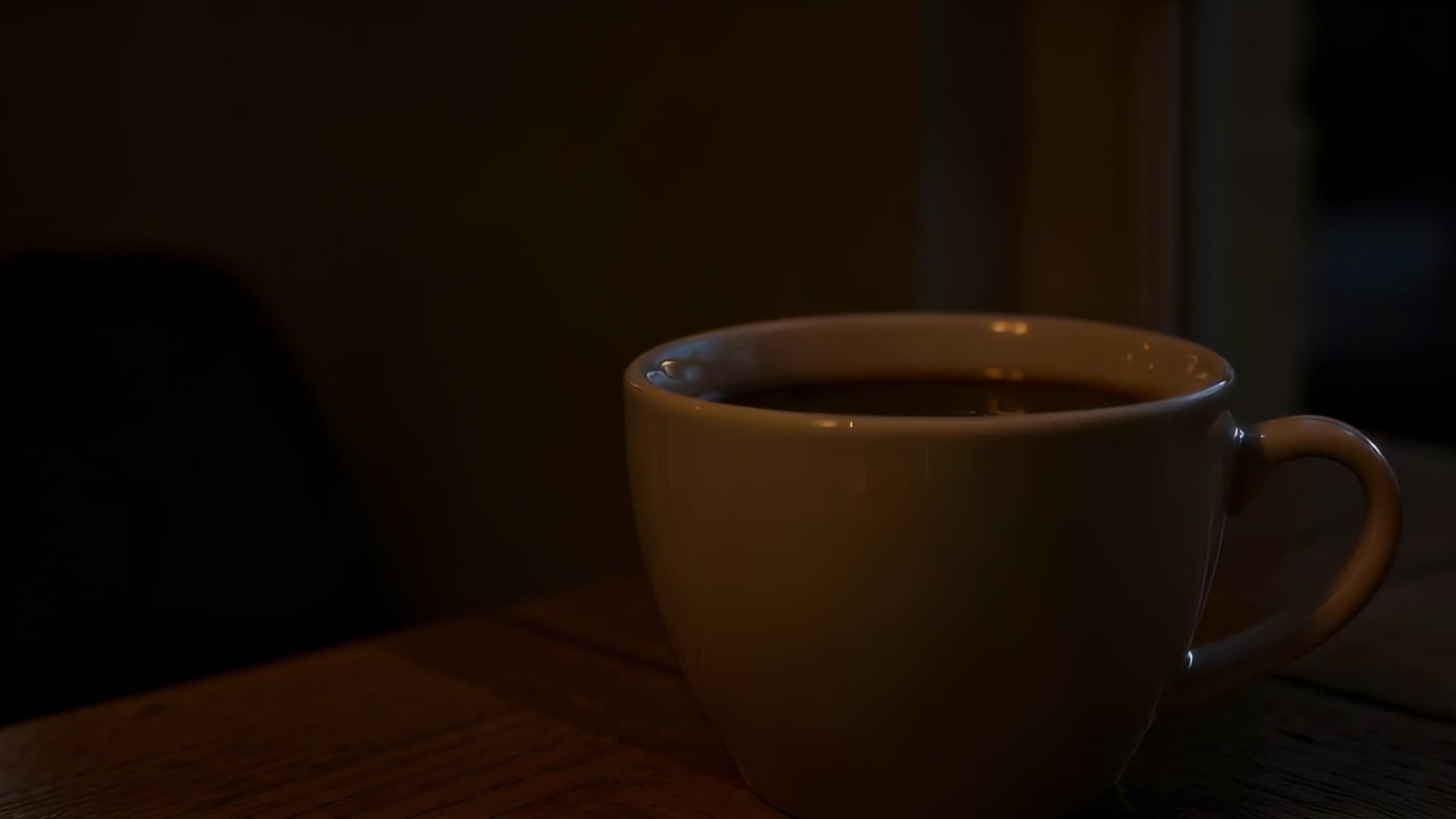 Steam rising from a cup by a window (night)