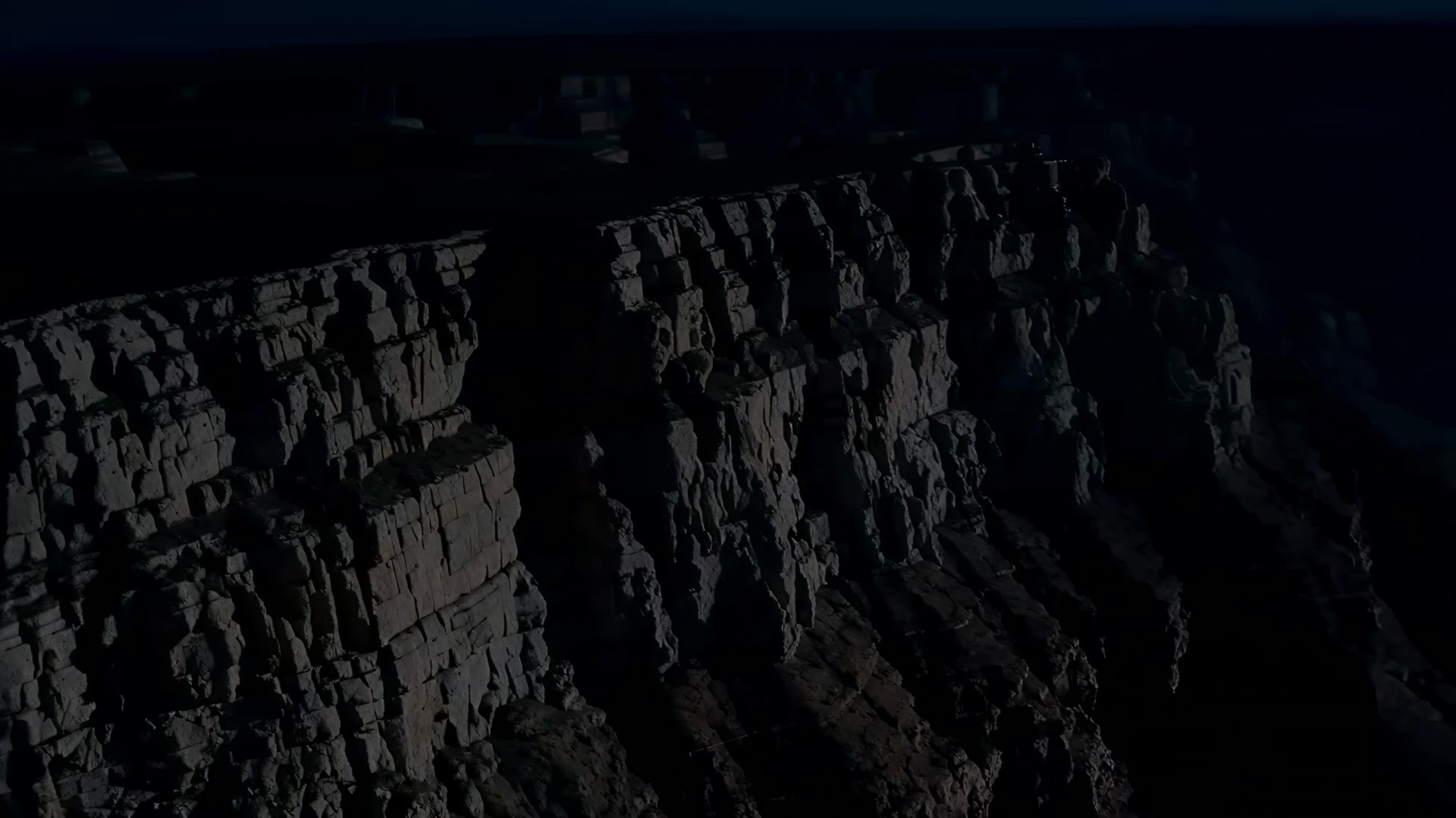 Aerial along a canyon rim (night)