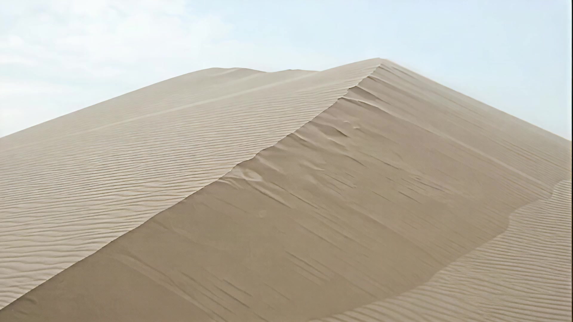 Wind lifting sand off a dune ridge, day version