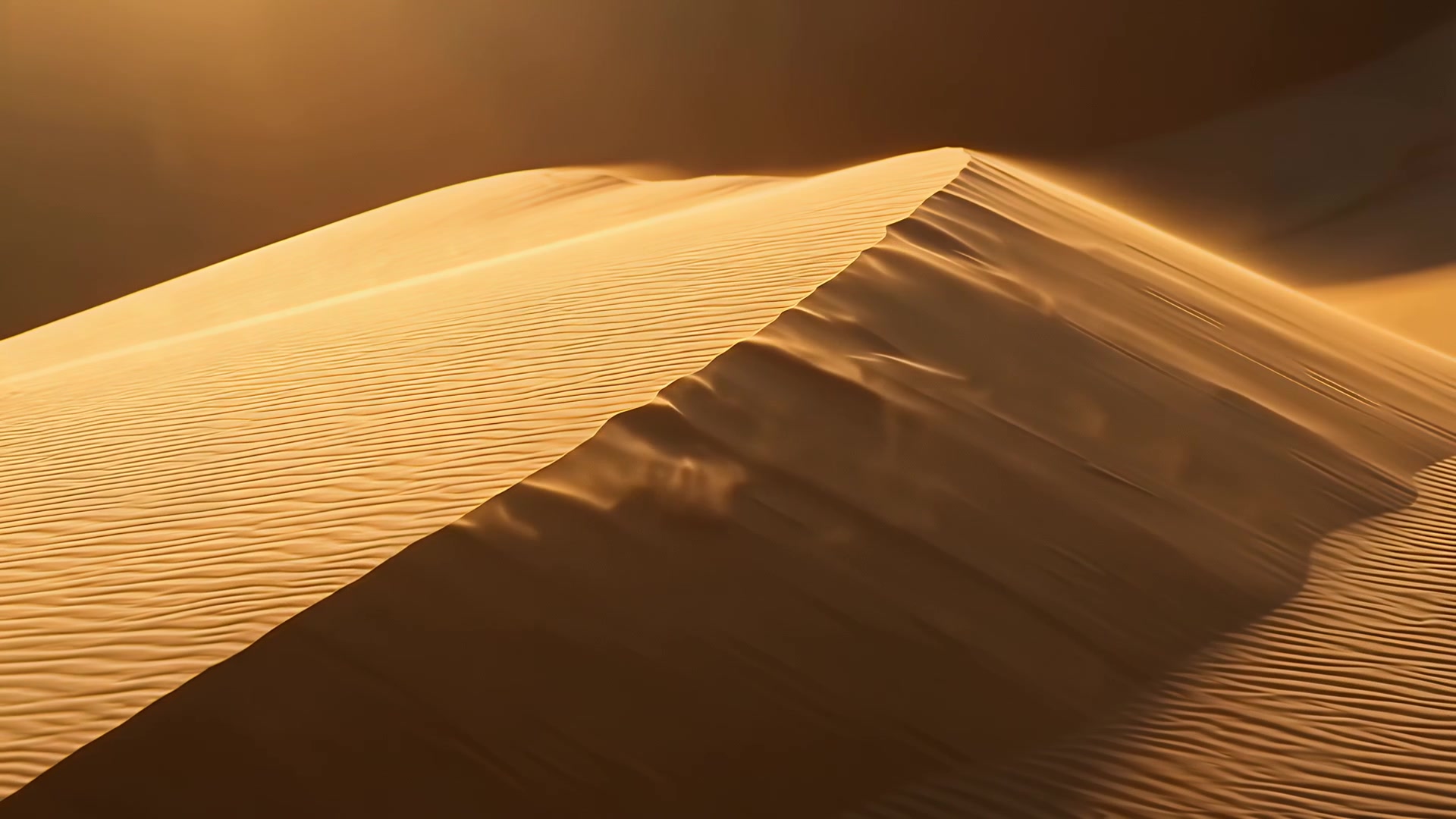 Wind lifting sand off a dune ridge (sunset)