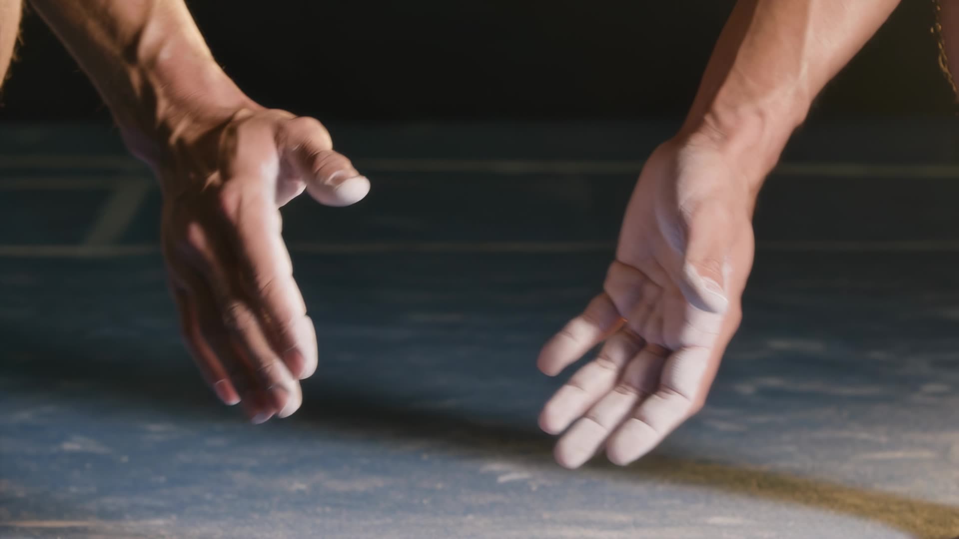 Chalked hands clapping, dust burst