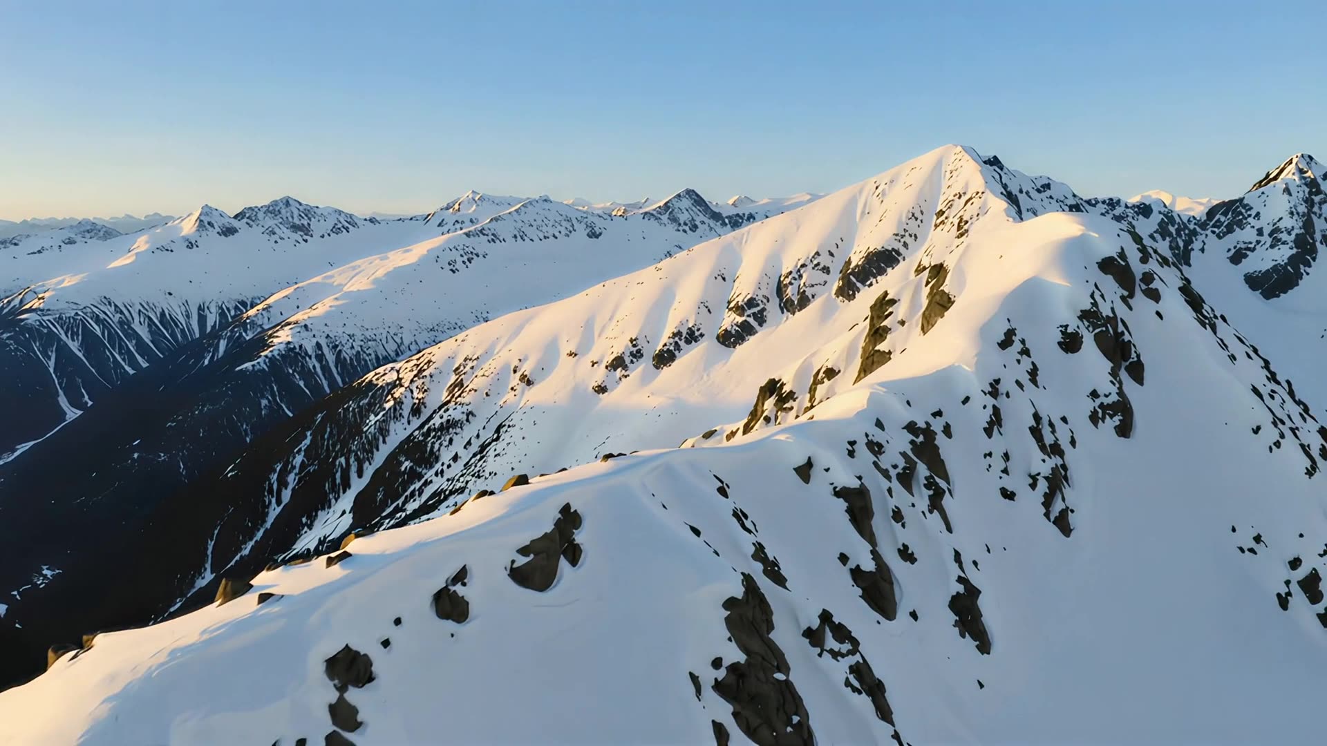 Aerial over snow-capped ridge, day version