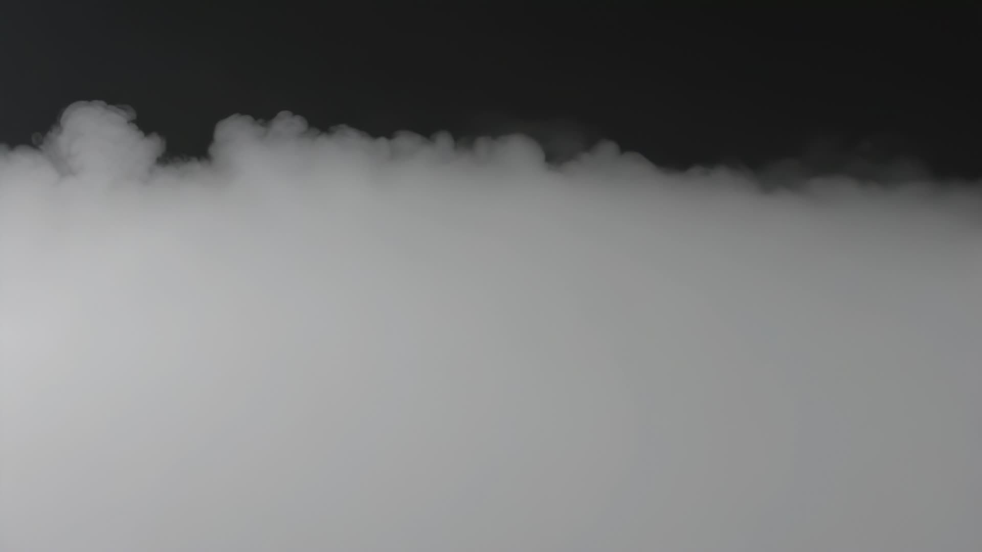 Fog drifting across black