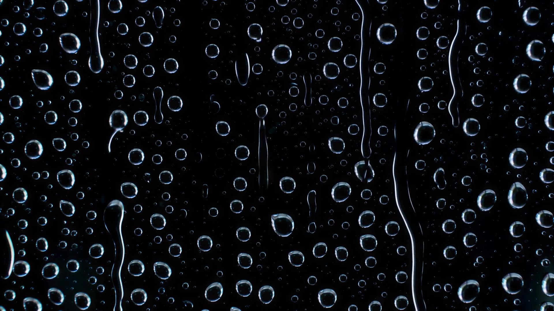 Rain on a window at night, close-up