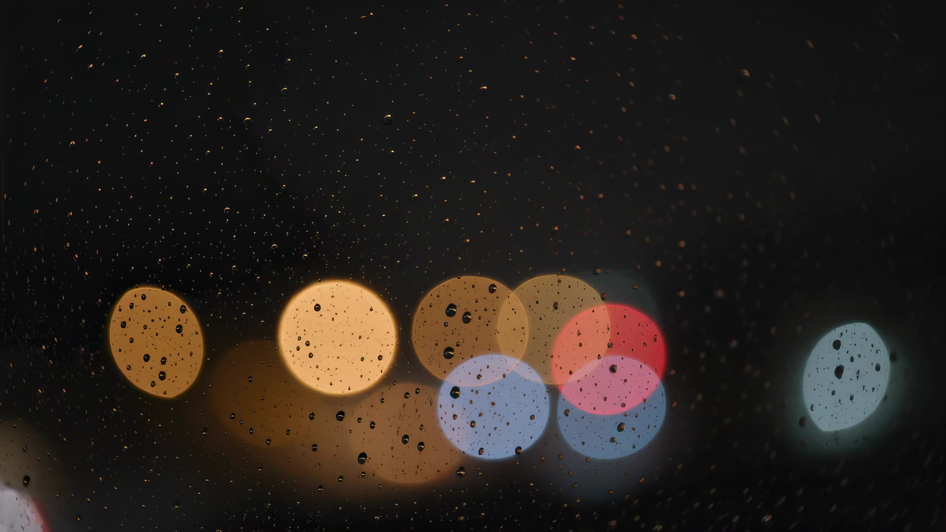 Rain on window with city bokeh at night